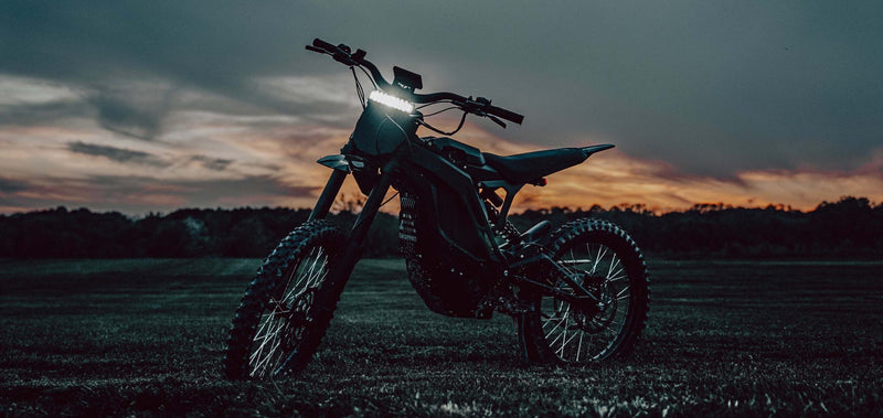 E-Ride Pro SS bei Sonnenuntergang auf einer Wiese im Offroad-Einsatz
